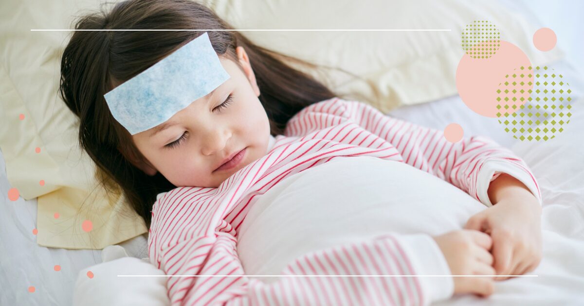 A young girl with a fever patch on her forehead lies in bed, resting peacefully while wearing pink striped pajamas.