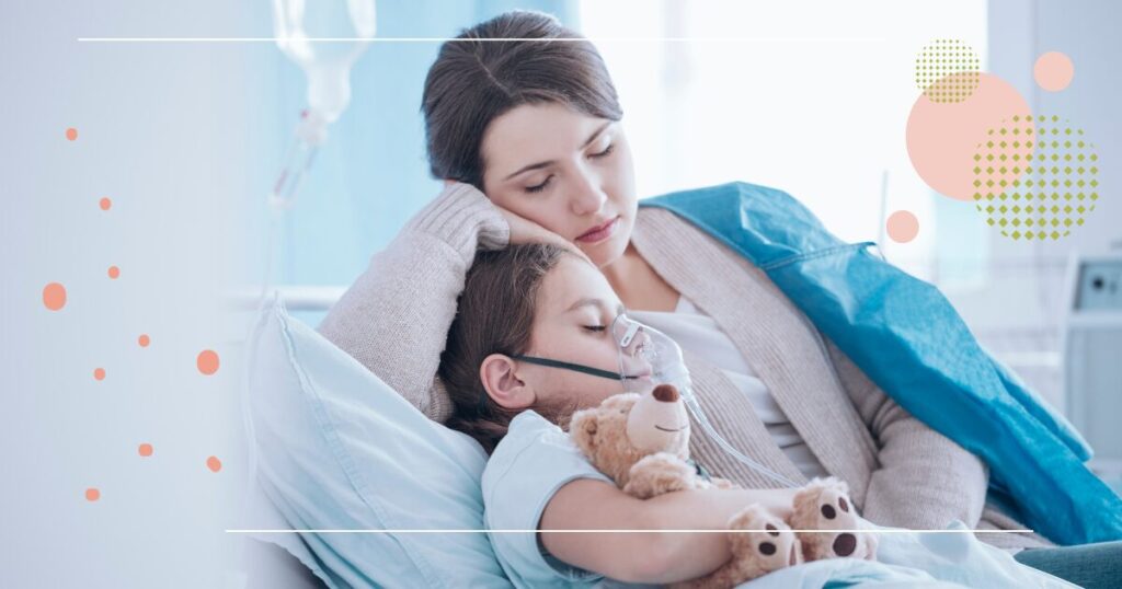 Mother and child resting together in a hospital bed; the child is wearing an oxygen mask and holding a teddy bear.
